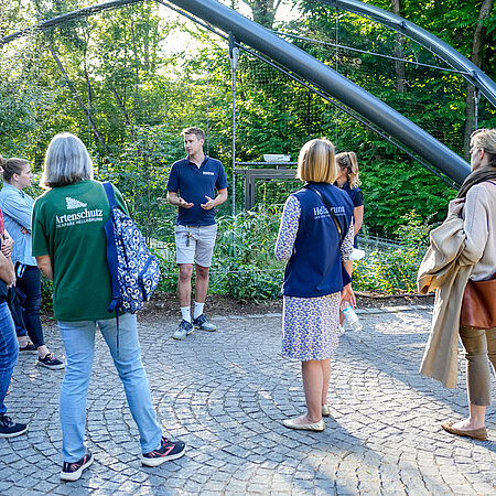 Hellabrunn Führung vor Flamingoanlage Ein Zoo-Guide führt eine Gruppe von Besuchern durch den Tierpark.