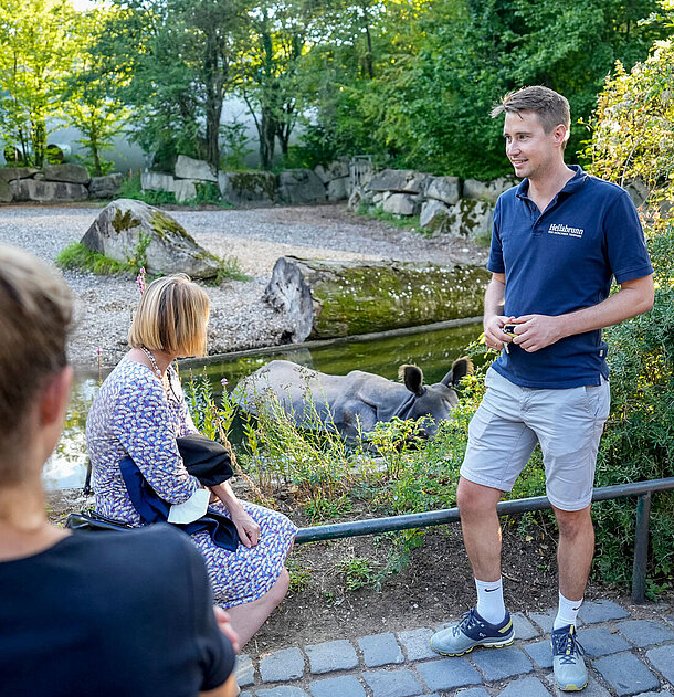 Ein Guide gibt eine Führung in Hellabrunn vor der Nashorn-Anlage.